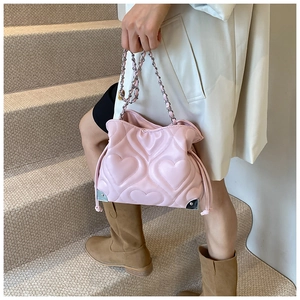 Détail du sac seau rose matelassé en cœurs avec chaîne argentée et coins en métal