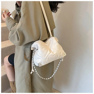 Détail du sac nuage blanc cassé avec matelassage en forme de cœur et sangle en chaîne métal