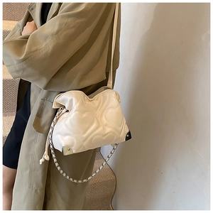 Détail du sac à bandoulière blanc crème avec surpiqûres en cœur et chaîne argentée