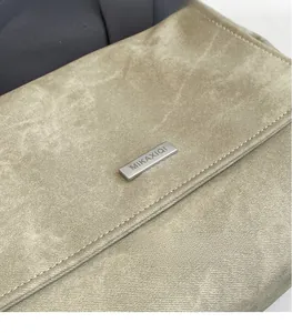 Macro detail of vintage textured leather with silver metal logo plaque and fine stitching