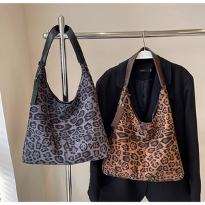 Detail view of leopard print hobo bags in grey and brown tones with leather straps