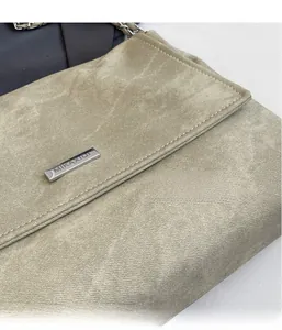 Close-up of khaki shoulder bag featuring matte suede texture and silver chain strap details