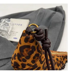 Dettaglio borsa leopardata con manico in pelle a nodo e anello in metallo dorato lucido