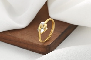 Detailed shot of hugging hands and heart ring on wooden block with fabric background