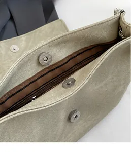 Detail of silver magnetic closure and striped lining on large leather tote bag