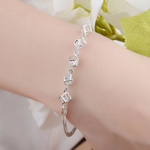 Dettaglio ravvicinato di un bracciale in argento con cubi e cristalli indossato al polso