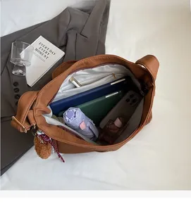 Top view of a large brown leather tote bag interior showing spacious compartments and storage