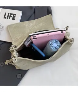 Detail view of large capacity crossbody bag interior holding a tablet and umbrella