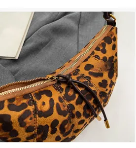Dettaglio borsa leopardata con cerniera dorata scorrevole e tiralampo in pelle marrone
