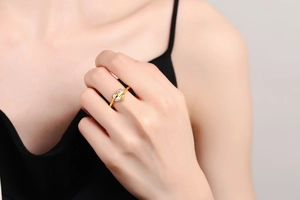 Macro detail of gold and silver hugging hands ring showing heart shaped creative design