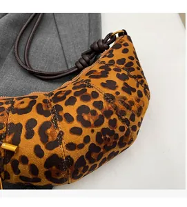 Dettaglio della borsa a mezzaluna leopardata con trama in pelle scamosciata e nodo
