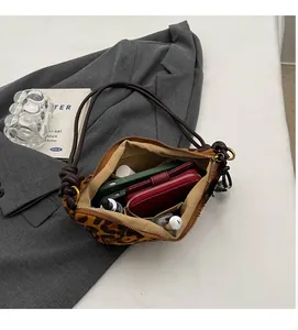 Dettaglio dell'interno capiente di una borsa leopardata con scomparti
