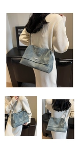 Close-up of textured blue denim shoulder bag featuring silver chain and metal hardware