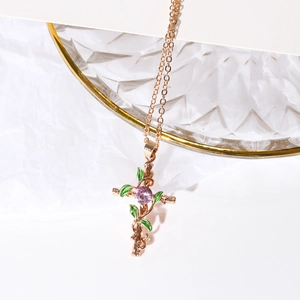 Cross necklace with leaf design and purple stone on elegant white textured background