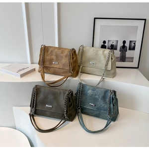 Group of textured shoulder bags in brown, white, olive, and denim with silver clasps