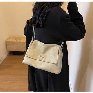 Detail view of light green matte tote with silver chain strap and Miramont metal plate