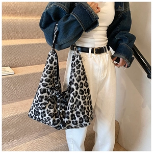 Détail du sac bandoulière en peluche léopard avec nœud décoratif et anneau métal