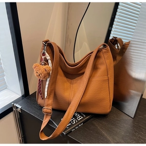 Detailed macro of vintage brown large hobo bag with teddy charm and woven rope accent