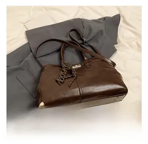 Detail of dark brown vintage shoulder bag with loving charm and metal bottom studs