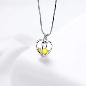 Collier avec pendentif cœur ajouré et cristal jaune central sur chaîne argentée