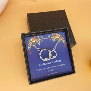 Collana a doppio anello intrecciato con cristalli in una scatola regalo floreale