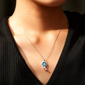 Minimalist hexagonal evil eye enamel necklace with sparkling zircon stones on a model