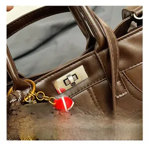 Detailed macro view of silver twist lock on brown lychee texture leather shoulder bag