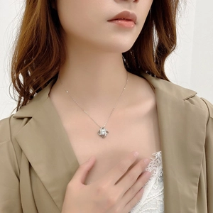 Collier trèfle argenté avec zircon scintillant porté par un mannequin élégant