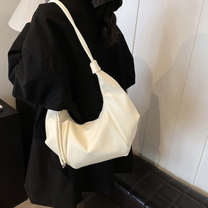 Minimalist cream white crescent shoulder bag with knotted strap and lychee grain leather