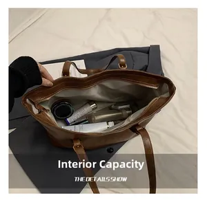 Macro view showing spacious internal capacity of the brown leather tote with zipper closure