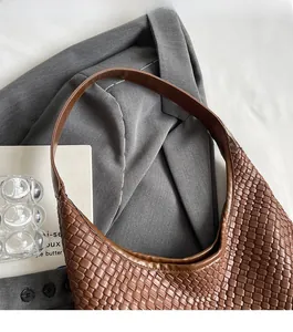 Detailed texture of brown woven hobo bag with a smooth leather shoulder strap