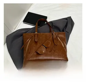 Detail view of large brown retro tote bag with golden protective metal feet on bottom