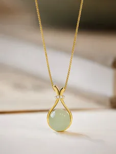 Macro detail of gold lucky bag pendant with green gemstone and diamond accents
