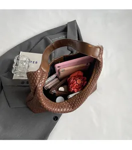 Top view of large brown woven leather hobo bag showing spacious interior and daily essentials
