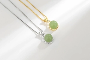 Detailed view of lucky bag pendant necklaces in gold and silver with green jade stones