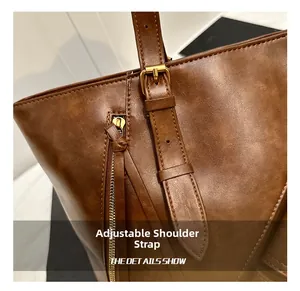 Detail of adjustable shoulder strap and gold-tone metal buckle on vintage brown tote bag
