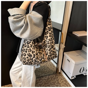Détail du sac hobo à motif léopard avec nœud décoratif et logo métallique