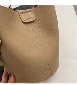 Detailed close-up of beige pebble leather bucket bag featuring Chio'2nd brand embossing