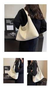 Detailed view of off-white woven hobo shoulder bag with matte leather texture and wide strap