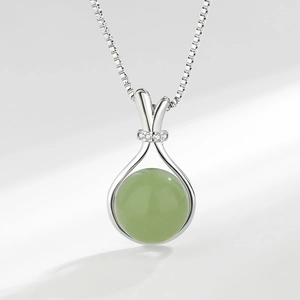 Elegant silver necklace with green agate pendant and sparkling accent stones on white backdrop