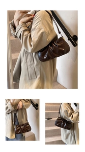 Close-up of pleated dark brown cloud bag with leather texture on indoor stairs
