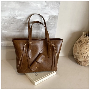 Detail of retro brown tote bag with zipper accents and small pouch on vintage books