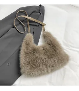 Detail of light brown faux fur shoulder bag with leather strap on grey suit