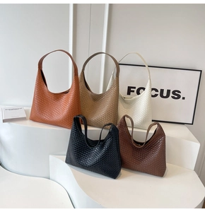 Collection of woven leather hobo bags in various colors displayed on a minimalist white stage