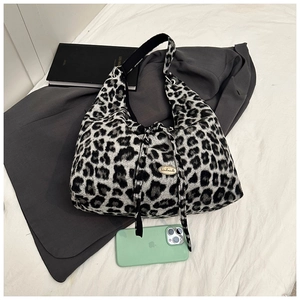 Detail of leopard print tote bag with handmade metal tag and wide shoulder strap