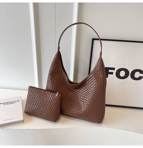 Detail of brown woven hobo shoulder bag with matching zipper pouch and leather texture