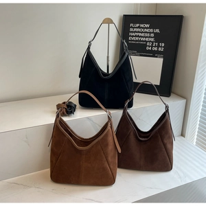 Detailed display of three minimalist suede tote bags in black, caramel, and coffee colors