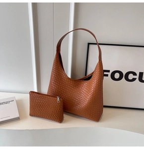 Close-up of caramel brown woven tote bag set with matching inner pouch on minimalist decor