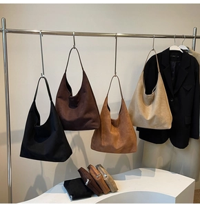 Dettaglio di borse hobo in camoscio in quattro colori terra con pochette abbinate