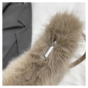 Macro view of light brown faux fox fur texture and silver metal zipper on a plush handbag